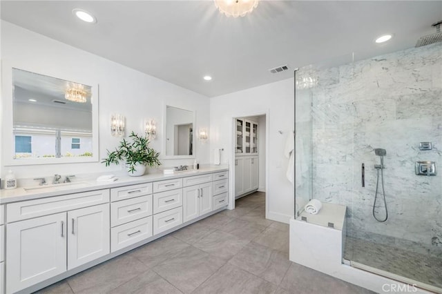 bathroom featuring recessed lighting, a sink, a marble finish shower, and double vanity