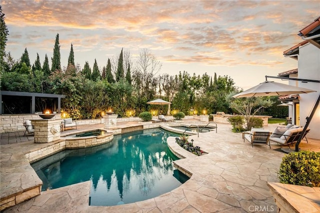 pool with a patio area and an in ground hot tub