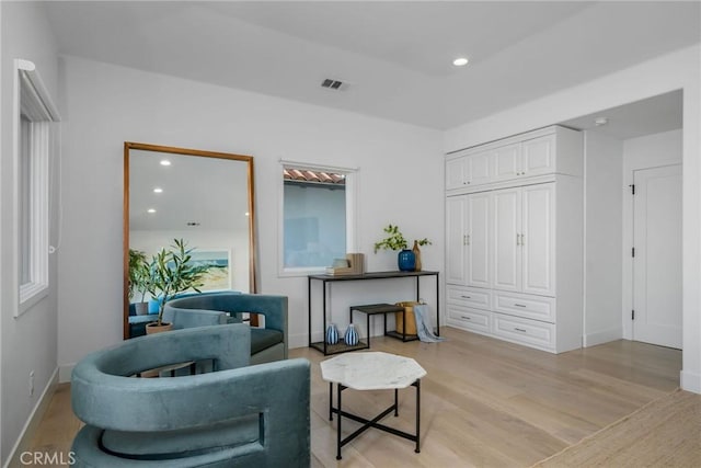 living area with baseboards, light wood-style flooring, visible vents, and recessed lighting