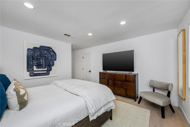 bedroom featuring wood finished floors, visible vents, and recessed lighting