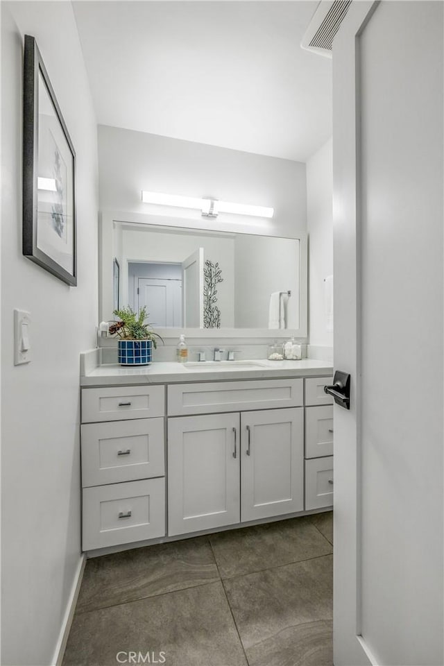 bathroom featuring baseboards, visible vents, tile patterned floors, and vanity