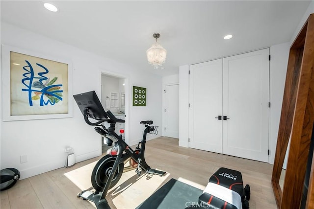 workout room with recessed lighting, wood finished floors, baseboards, and an inviting chandelier