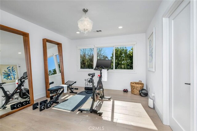 exercise area with recessed lighting, a chandelier, wood finished floors, and baseboards
