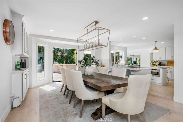 dining area with light wood-type flooring and recessed lighting