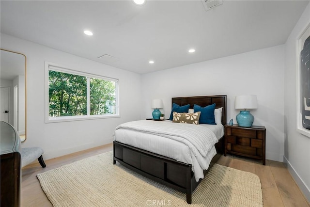bedroom with baseboards, recessed lighting, and light wood-style flooring