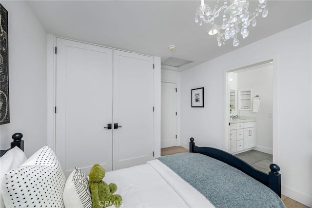 bedroom with ensuite bathroom, baseboards, and a closet