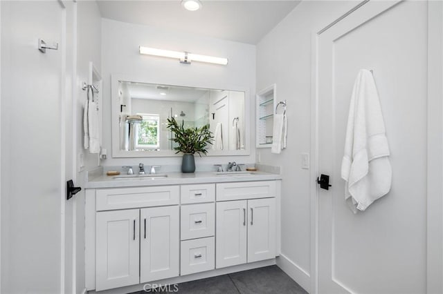 bathroom featuring tile patterned flooring, a sink, and double vanity