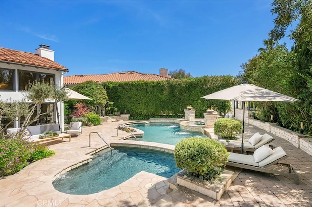 outdoor pool featuring an in ground hot tub and a patio