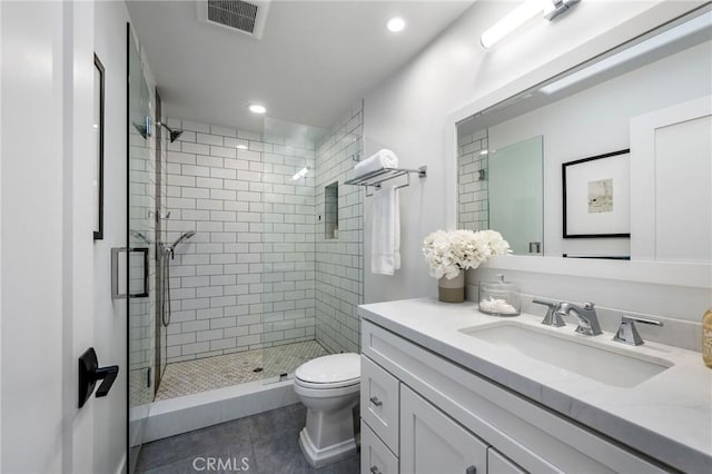 bathroom featuring toilet, visible vents, tile patterned flooring, a shower stall, and vanity