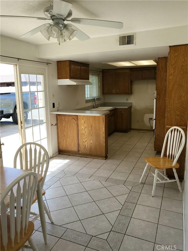 4322 Temescal Ave, Norco, CA 92860 - kitchen with a sink, ceiling fan, a peninsula, light tile patterned floors, and light countertops