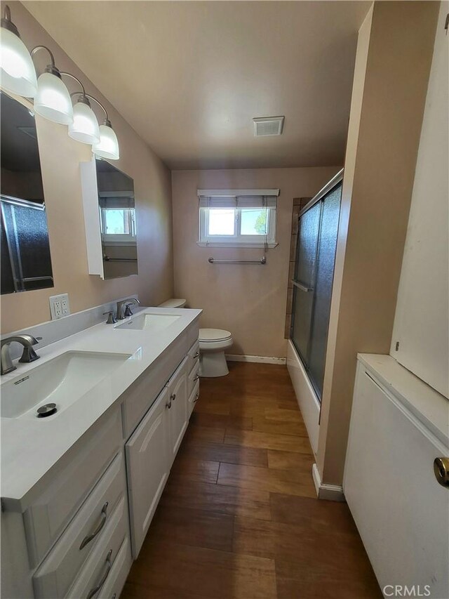 4322 Temescal Ave, Norco, CA 92860 - bathroom with toilet, wood finished floors, double vanity, baseboards, and enclosed tub / shower combo