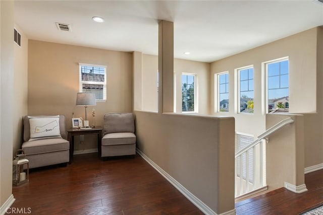 living area featuring baseboards, a healthy amount of sunlight, and visible vents