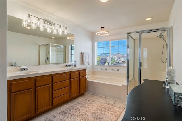 bathroom featuring double vanity, a shower stall, a garden tub, and a sink