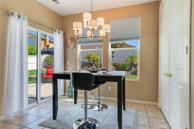 tiled dining area featuring baseboards and a chandelier