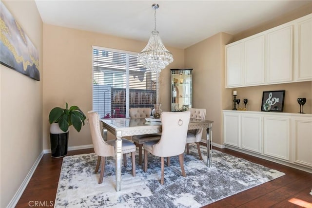 dining room with a chandelier, baseboards, and dark wood-type flooring