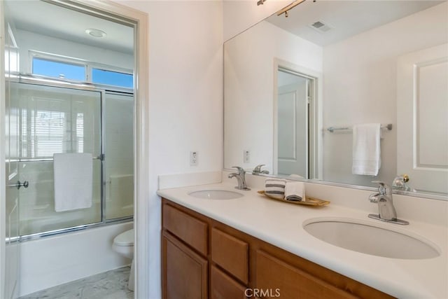 full bath featuring visible vents, a sink, double vanity, and toilet