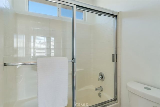bathroom with toilet and enclosed tub / shower combo