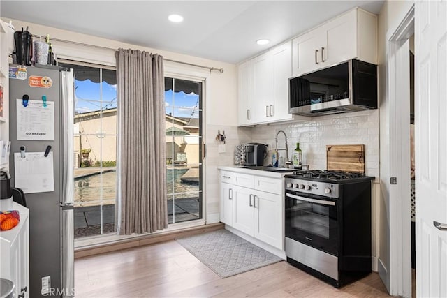 4045 N Walnuthaven Dr, Covina, CA 91722 - kitchen with decorative backsplash, stainless steel appliances, a sink, and white cabinetry