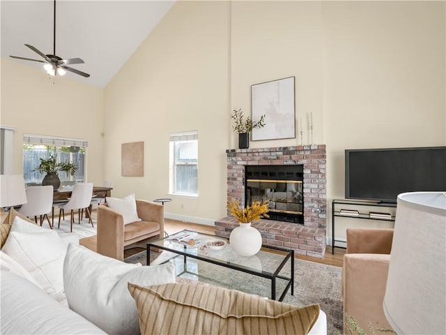 1523 E Pryor Dr, Fresno, CA 93720 - living room with light wood-type flooring, baseboards, a ceiling fan, a fireplace, and high vaulted ceiling
