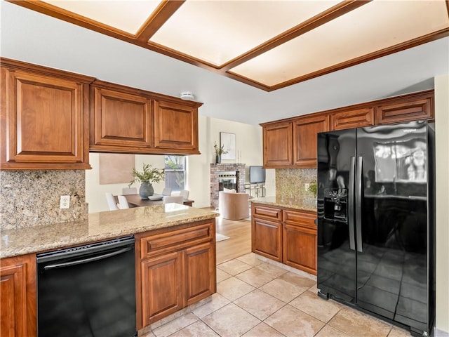 1523 E Pryor Dr, Fresno, CA 93720 - kitchen with brown cabinets, backsplash, light stone countertops, black appliances, and a fireplace