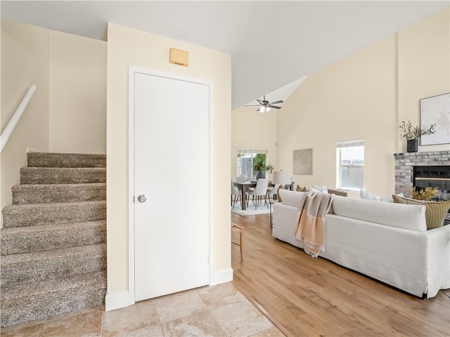 1523 E Pryor Dr, Fresno, CA 93720 - living room featuring stairs, a ceiling fan, baseboards, a brick fireplace, and high vaulted ceiling