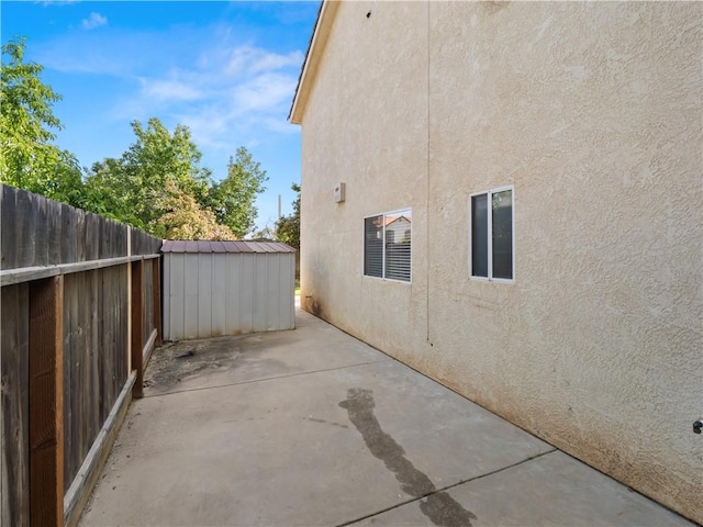 1523 E Pryor Dr, Fresno, CA 93720 - view of property exterior featuring a storage shed, fence, an outdoor structure, a patio, and stucco siding
