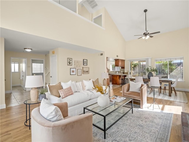 1523 E Pryor Dr, Fresno, CA 93720 - living area with high vaulted ceiling, a ceiling fan, light wood finished floors, baseboards, and visible vents