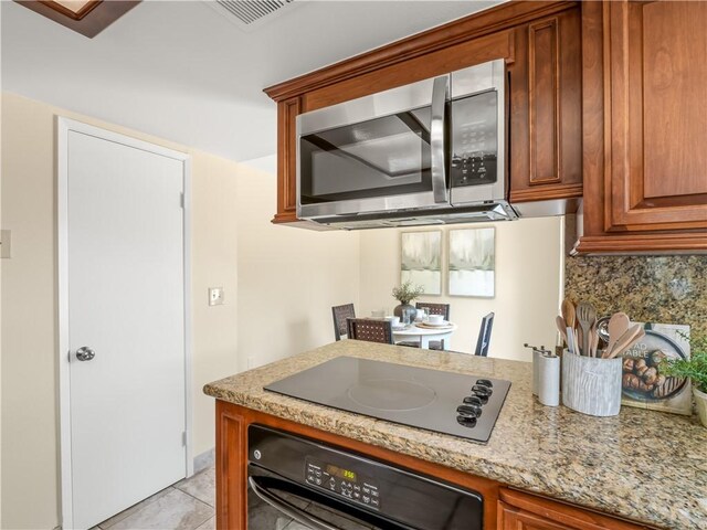1523 E Pryor Dr, Fresno, CA 93720 - kitchen with visible vents, backsplash, light stone countertops, brown cabinetry, and black appliances