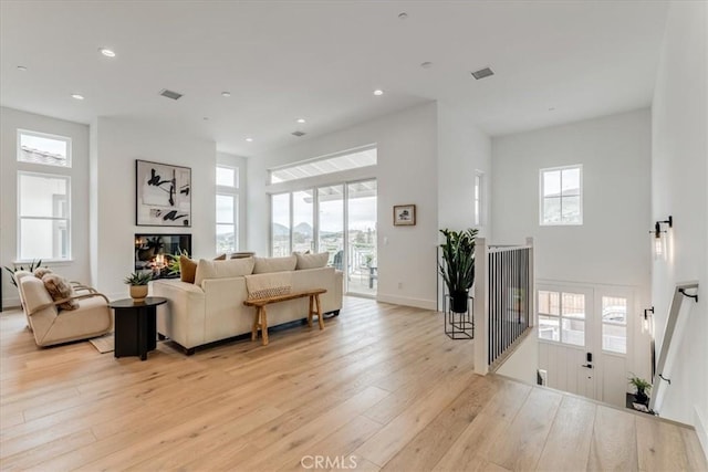living room featuring light wood-type flooring, recessed lighting, and a healthy amount of sunlight