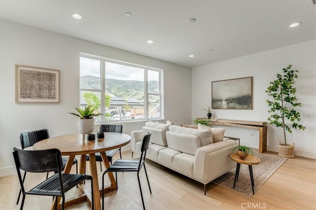 living room featuring recessed lighting, baseboards, and light wood-style floors