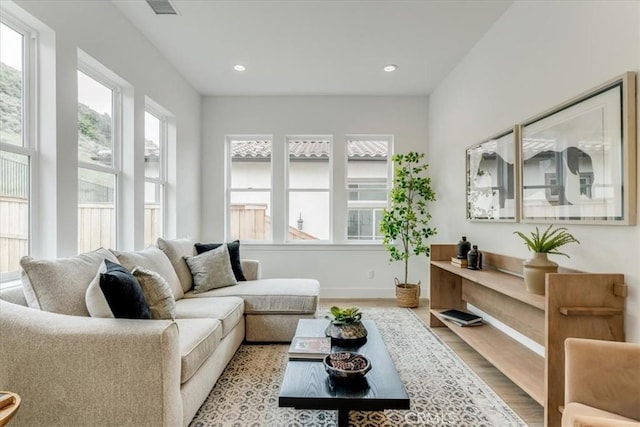 living room featuring recessed lighting, baseboards, visible vents, and wood finished floors