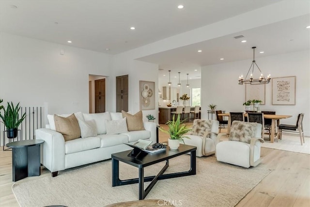 living room featuring recessed lighting, visible vents, light wood finished floors, and a chandelier