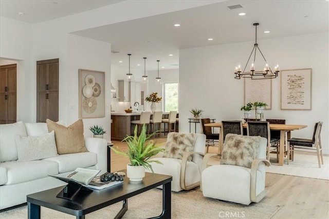 living room featuring visible vents, a chandelier, recessed lighting, and light wood finished floors