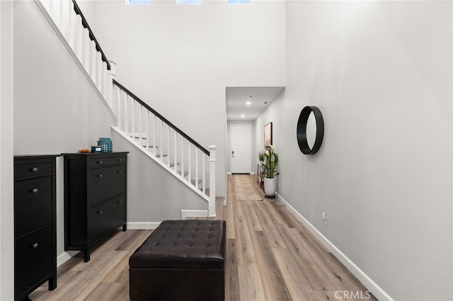 3693 S Grower Ave, Ontario, CA 91761 - entryway with baseboards, a towering ceiling, stairs, and light wood-style flooring