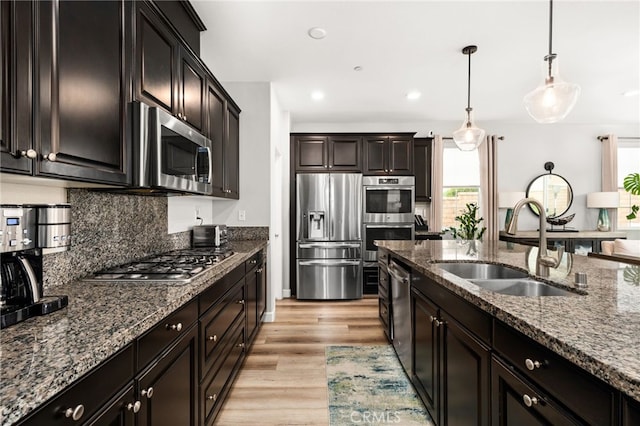 3693 S Grower Ave, Ontario, CA 91761 - kitchen with stainless steel appliances, dark stone counters, a sink, and a wealth of natural light