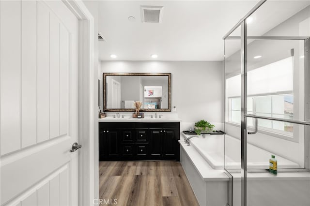 3693 S Grower Ave, Ontario, CA 91761 - full bath featuring wood finished floors, a sink, a bath, double vanity, and visible vents