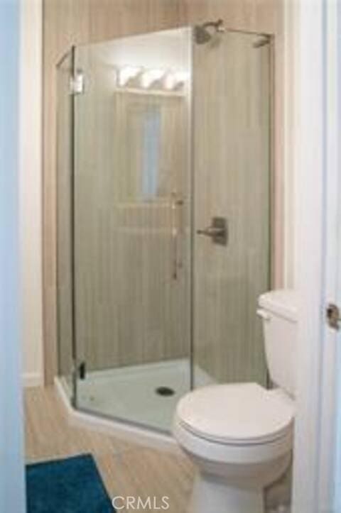 bathroom featuring toilet and a stall shower