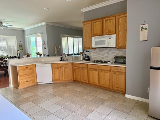 10485 Nobleton Rd, Apple Valley, CA 92308 - kitchen with a ceiling fan, crown molding, white appliances, light tile patterned floors, and a peninsula