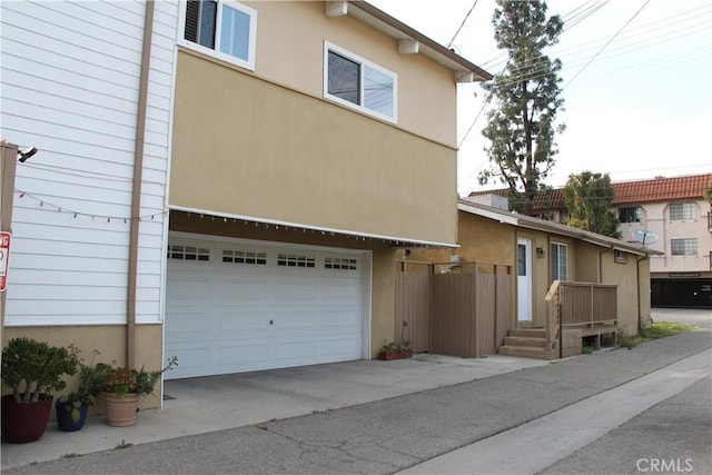 view of home's exterior featuring stucco siding, an attached garage, and driveway