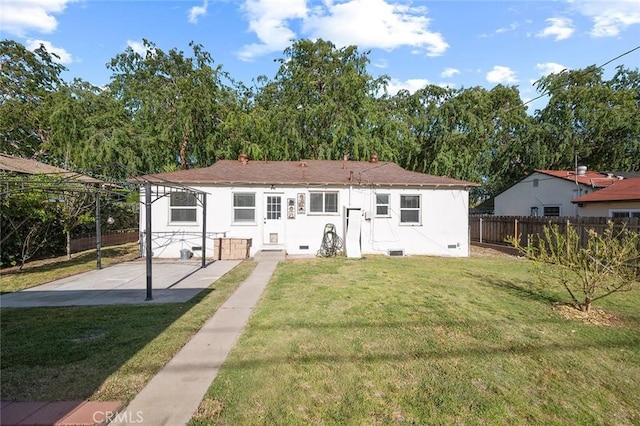 rear view of property with a lawn, crawl space, fence, and a patio area