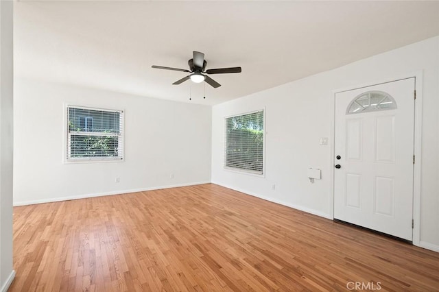 interior space featuring light wood-type flooring, baseboards, and ceiling fan