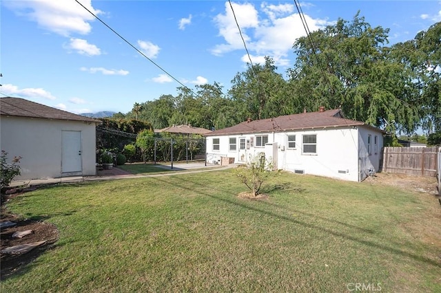 rear view of property with a lawn and fence