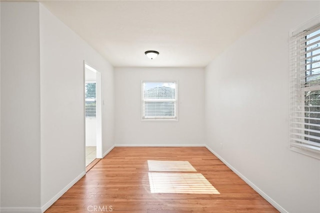 unfurnished room featuring light wood-type flooring and baseboards