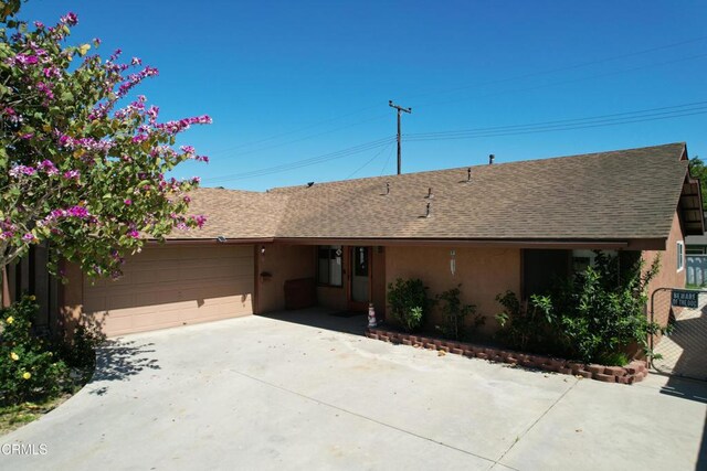 ranch-style house featuring driveway, a garage, stucco siding, and a shingled roof