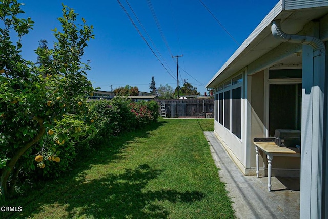 view of yard featuring a sunroom and fence