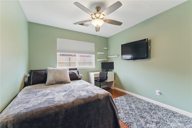 bedroom with a ceiling fan, baseboards, visible vents, and wood finished floors