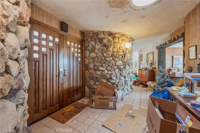 foyer with a textured ceiling and light tile patterned floors