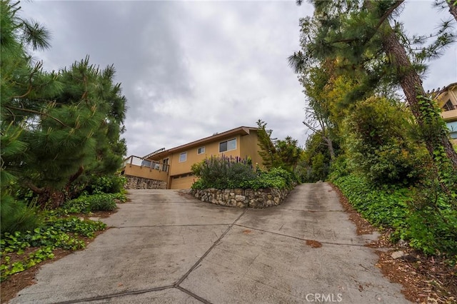 view of home's exterior with a garage, concrete driveway, and stucco siding