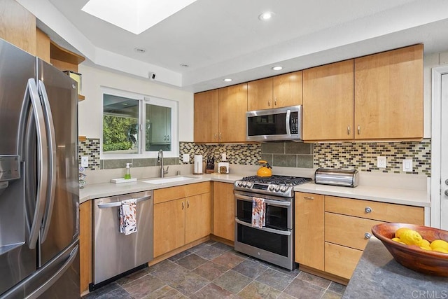 2406 Mcdougal Pl, Alpine, CA 91901 - kitchen with stainless steel appliances, light countertops, a skylight, decorative backsplash, and dark stone finish floors