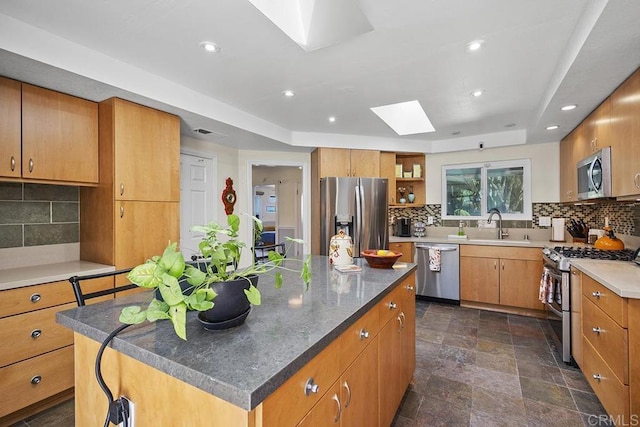2406 Mcdougal Pl, Alpine, CA 91901 - kitchen featuring appliances with stainless steel finishes, a skylight, a kitchen island, decorative backsplash, and open shelves